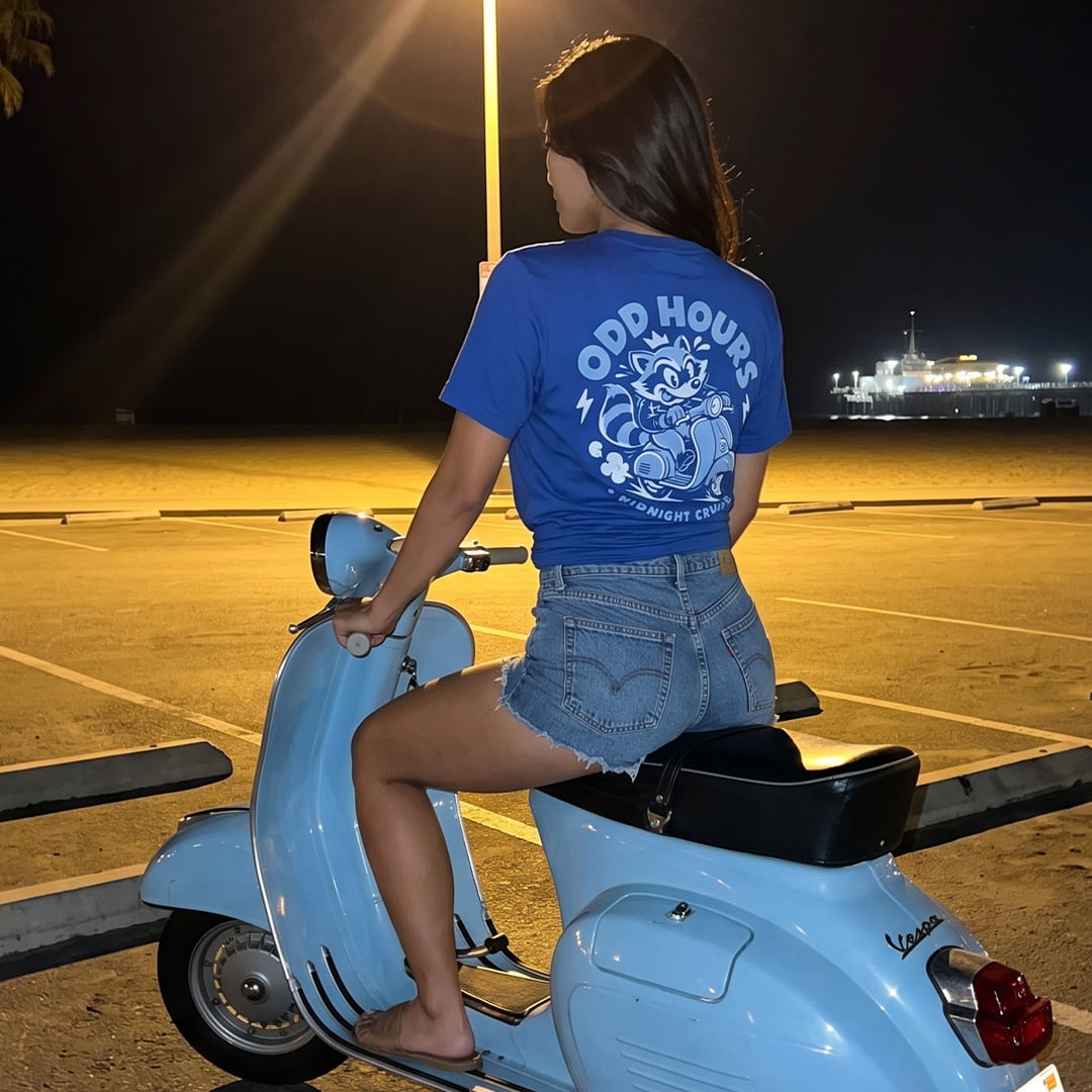 Odd Hours Midnight Cruise tee worn beside a scooter at night